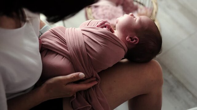 Newborn Photographer Swaddles A Baby During A Studio Photoshoot