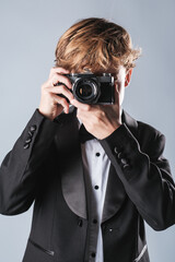 Preteen boy taking photo with camera in studio