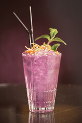 Pink cocktail with ice cubes in glass on counter