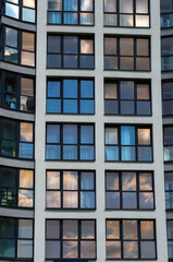 Windows with Black Casements on Facade of Modern Building. Sky Reflections in Windows Glass.    