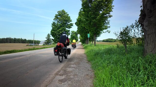 2 cyclotourists riding on road in quebec canada