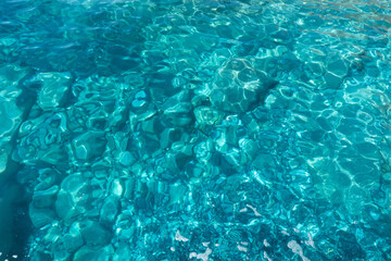 Shallow turquoise sea, clear water, stones on the bottom