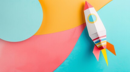 A paper rocket in vibrant colors sits atop a multicolored background, symbolizing creativity, childhood, and dreams of exploration.