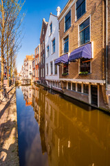 Historic buildings border a canal, along Voldersgracht street, in the old center of Delft, The Netherlands.