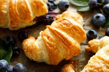 Croissant stuffed with blueberries, top view. Delicious breakfast or dessert