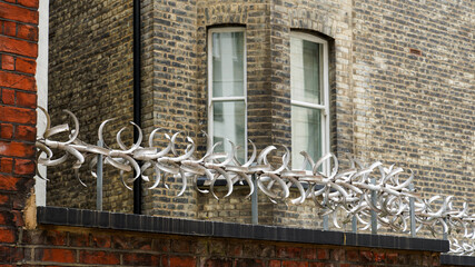 selective focus on a brick security wall with a spinning metal anti climb topper