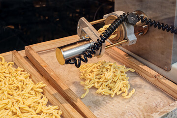 looking through a window into a shop making fresh strozzapreti pasta. Strozzapreti is sometimes...