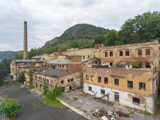 Historic old classic classical german19th 20th century ruined derelict abandoned textile manufacturing industrial factory building  brickwork cracked concrete facade scene with broken wooden roof 