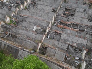 Historic old classic classical german19th 20th century ruined derelict abandoned textile manufacturing industrial factory building  brickwork cracked concrete facade scene with broken wooden roof 