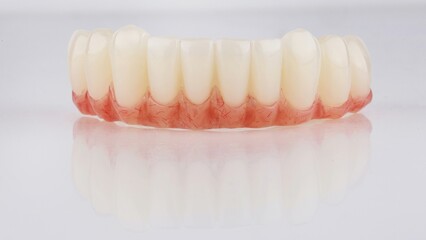 temporary prosthesis made of plastic with artificial gum for the lower jaw on a white background
