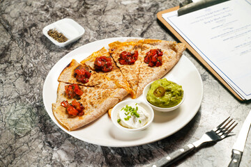 Tortilla Chips with Tomato Salsa Sauce, dip, fork and knife served in plate isolated on grey marble background side view of hong kong food