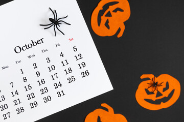 Calendar 31st of October date. Halloween background, planning party. Flat lay. Top view photo of calendar, Halloween decorations pumpkins, spiders on black and orange background. - Powered by Adobe