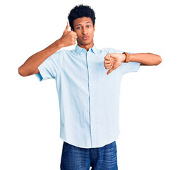 Young african american man wearing casual clothes doing thumbs up and down, disagreement and agreement expression. crazy conflict