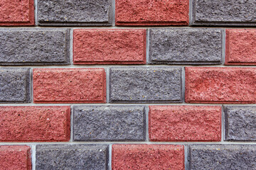 Close-up of a red and grey brick wall pattern. A detailed close-up image of a red and grey brick wall, showcasing the texture and pattern of the bricks.