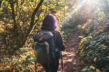 Person with purple hair hiking through a sunlit forest path surrounded by dense foliage.