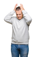 Middle age arab man wearing sport sweatshirt over isolated background suffering from headache desperate and stressed because pain and migraine. Hands on head.