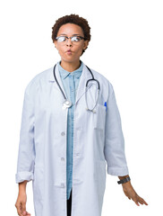 Fototapeta premium Young african american doctor woman wearing medical coat over isolated background making fish face with lips, crazy and comical gesture. Funny expression.