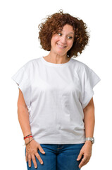 Beautiful middle ager senior woman wearing white t-shirt over isolated background smiling looking side and staring away thinking.