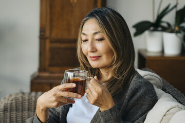 Woman Enjoying Warm Beverage at Home in Afternoon Sunlight