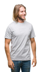 Fototapeta premium Young handsome man with long hair over isolated background looking away to side with smile on face, natural expression. Laughing confident.