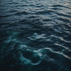 The ocean glistens under the bright midday sun, with gentle waves creating a peaceful and soothing rhythm