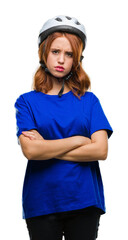 Young beautiful woman wearing cyclist helmet over isolated background skeptic and nervous, disapproving expression on face with crossed arms. Negative person.