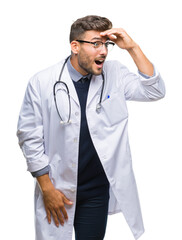 Young handsome doctor man over isolated background very happy and smiling looking far away with hand over head. Searching concept.