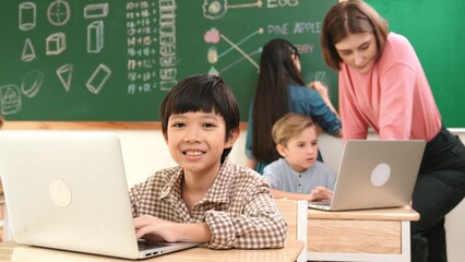 Cute boy coding engineering prompt while attractive girl drawing picture at blackboard. Caucasian...