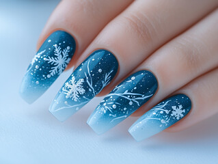 Festive winter-themed nail art featuring snowflakes on gradient blue nails