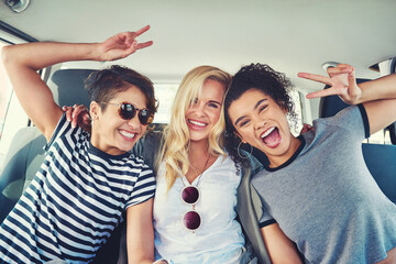 Friends, women and happy in car with peace sign on portrait for traveling, road trip and holiday. Journey, people and excited as passenger on vehicle or taxi for tour, vacation and adventure © Frank Coop/peopleimages.com