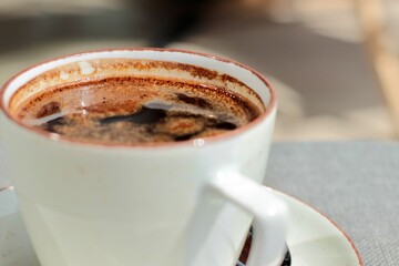 A white cup is filled with morning coffee