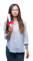 Young asian woman holding degree over isolated background with a confident expression on smart face thinking serious