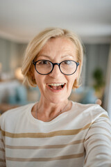 Portrait of one mature blonde caucasian woman with eyeglasses at home