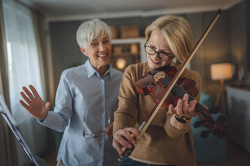 Private music teacher give violin lesson mature senior woman at home