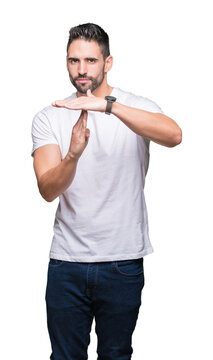 Young man wearing casual white t-shirt over isolated background Doing time out gesture with hands, frustrated and serious face