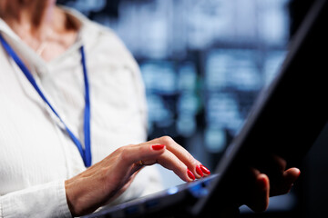 Efficient technician using laptop, ensuring valuable data remains shielded from potential security pitfalls, safeguarding server room devices against unauthorized access and vulnerabilities, close up