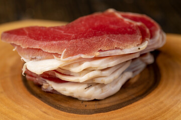 sliced ham with bacon on a board