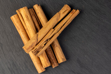 Thick wooden cinnamon on a black slate board