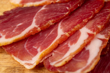 a piece of cured pork ham with thin layers of lard on the table