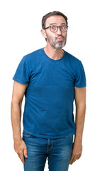 Obraz premium Handsome middle age hoary senior man wearin glasses over isolated background making fish face with lips, crazy and comical gesture. Funny expression.