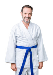 Handsome middle age senior man wearing kimono uniform over isolated background with a happy and cool smile on face. Lucky person.