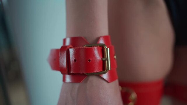 bdsm domination and submission role playing games, bondage sexy woman in red leather handcuffs with chain and leg harness 