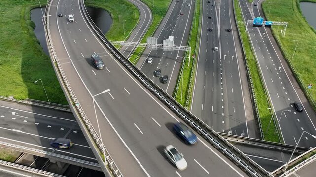 Aerial drone view of a multi-level highway intersection with moving cars near the city of Rotterdam, The Netherlands. Trucks move along a multi-level road junction. The concept of the urban.