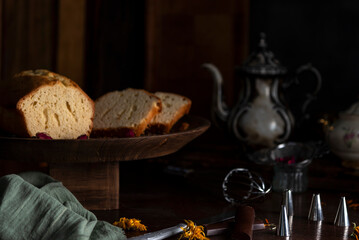 Vanilla pudding or cake on wood with antique tea set and hands sprinkling sugar for snack or breakfast 