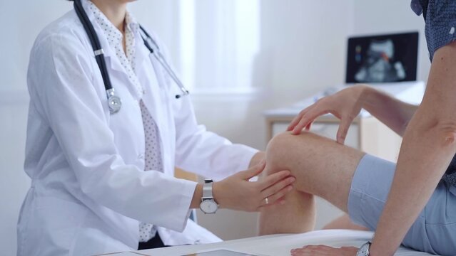 Doctor is carefully examining a patient's knee, providing personalized care and support. Medicine and orthopedic concept