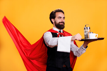 Luxury waiter with cape holds tray in studio, feeling confident and powerful while he is serving people at restaurant. Man with butler occupation indicated determination, dining personnel.