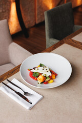 Greek salad on a large white plate. Restaurant food service, brunch, lunch, banquet.