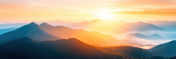 A breathtaking sunrise casts golden hues over tranquil mountains, enveloping the landscape in soft mist and warmth during the early morning light