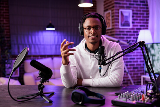 African american vlogger recording online show on camera, using sound equipment in studio. Portrait of content creator talking to audience looking at camera and filming social media channel vlog
