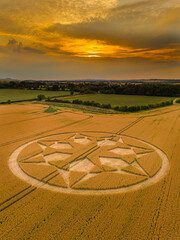 Aerial view of an intricate geometric crop circle formation in a wheat field near Marten in Wiltshire, England, UK